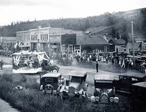 Automobiles, a float and groups of people