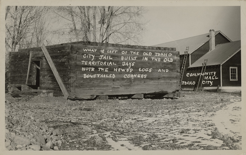 Postcard of the old Idaho City jail in Idaho City, Idaho. |  What is left of the old Idaho City jail built in the old territorial days. Note the hewed logs and dovetailed corners. Community Hall, Idaho City.