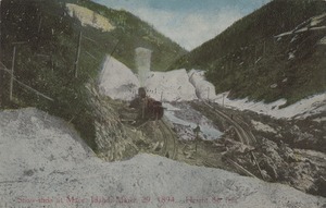 Postcard of railroad tracks after a snow slide on Canyon Creek near Mace, Idaho.