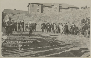 Postcard of a game of "pick-a-back" relay between freshman and sophomores at the University of Idaho campus in Moscow, Idaho.