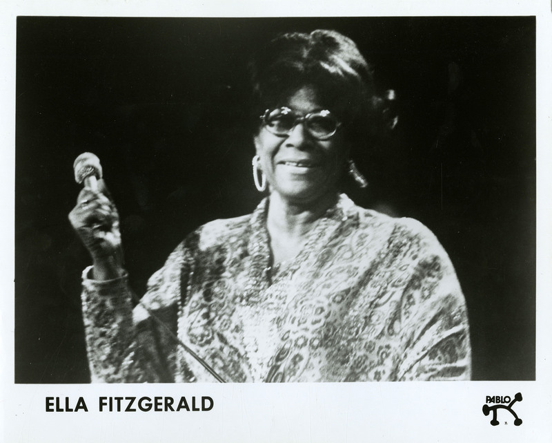 item thumbnail for Ella Fitzgerald in a paisley dress, holding a microphone
