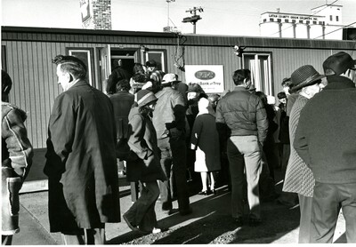 People waiting outside trailer office of First Bank of Troy