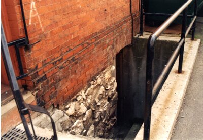 Foundation rock on brick building in alley