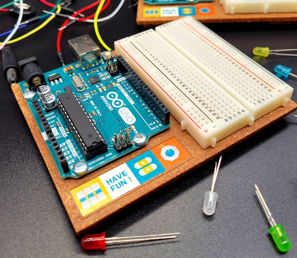 blue arduino uno circuit board with wires and LED components