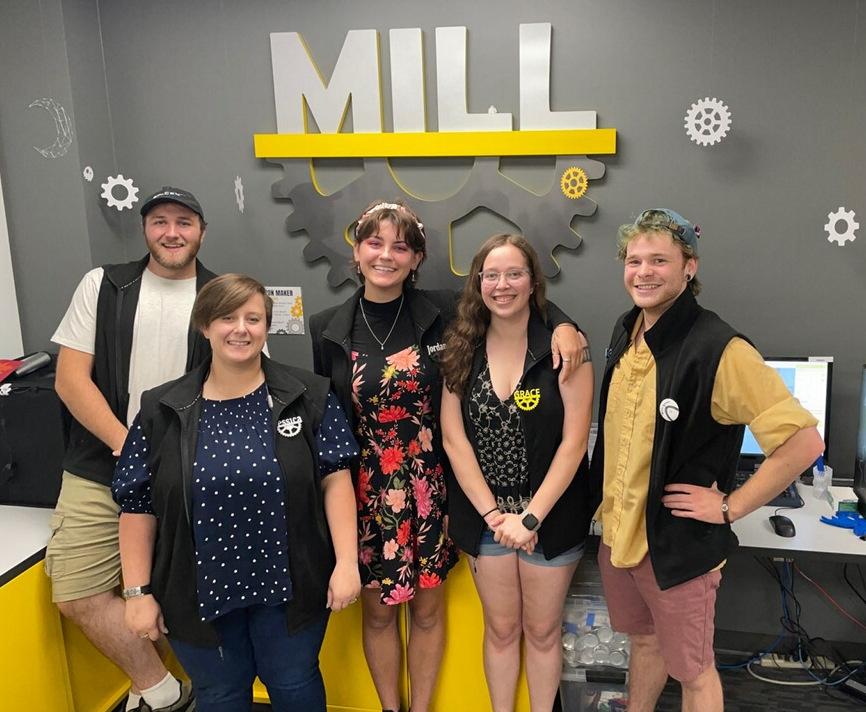 group of smiling students in the maker space